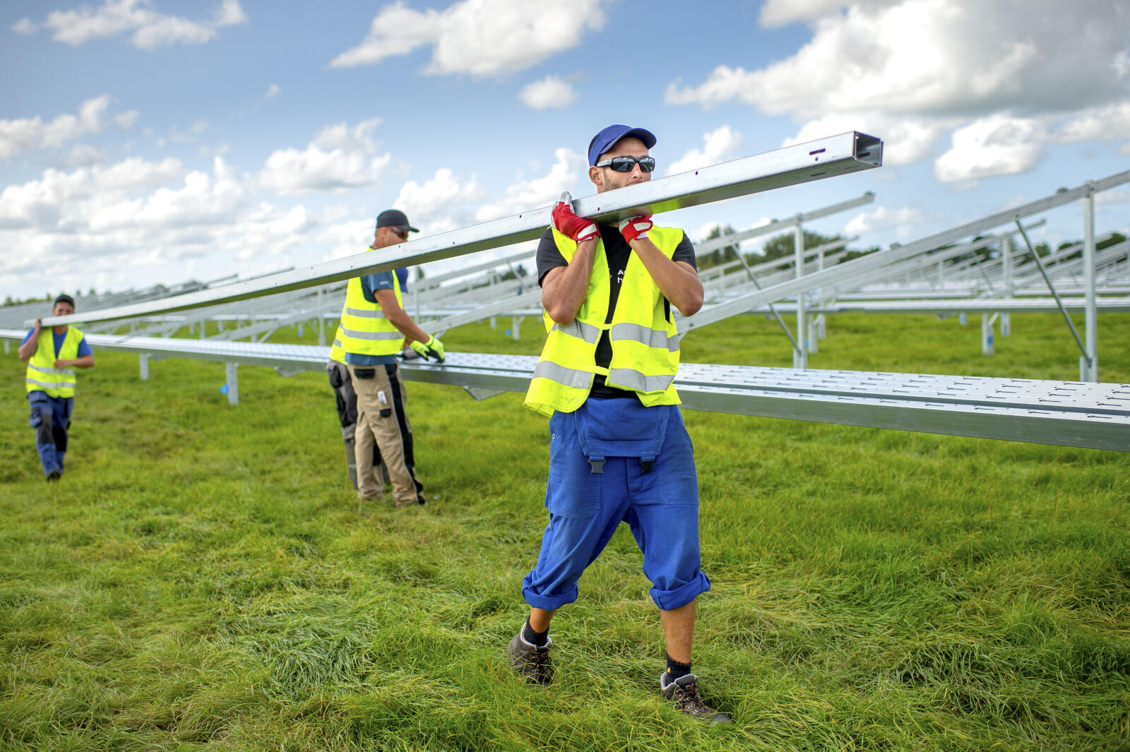 Installateurs zijn druk bezig met het aanleggen van een zonnepanelenpark naast industrieterrein De Swadde in Buitenpost