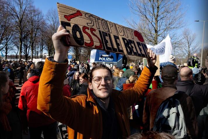 Een man houdt een bordje omhoog tijdens een demonstratie in Den Haag