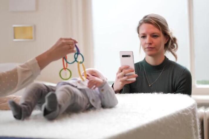 Een fysiotherapeut gebruikt de app Skully Care om een babyhoofdje te meten